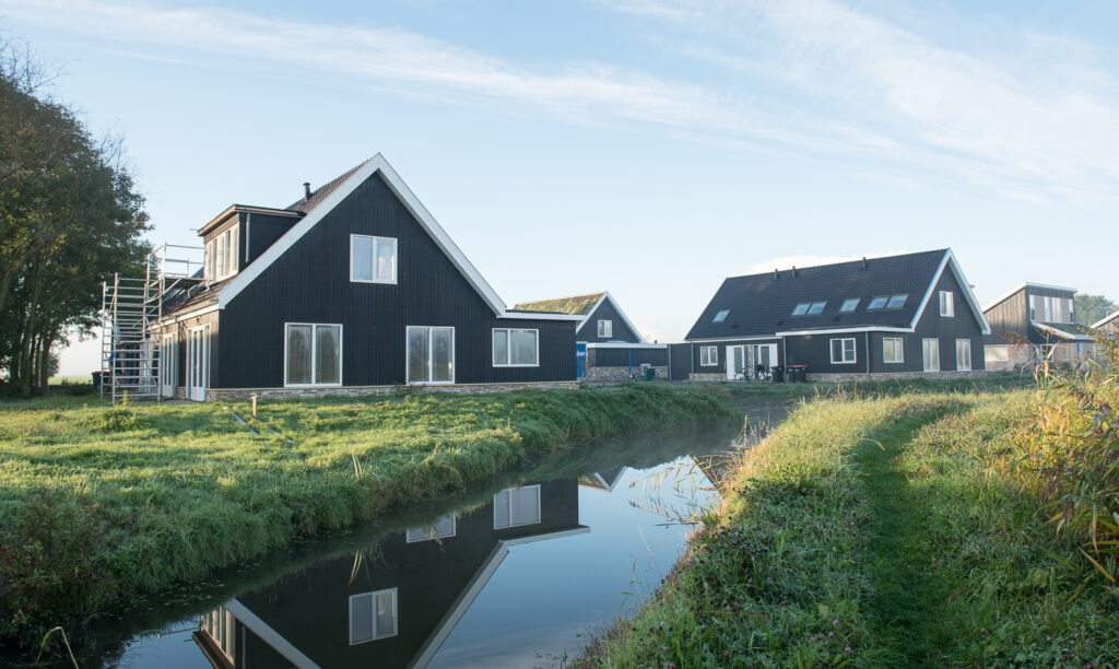 Foto van huizen met gras en sloot